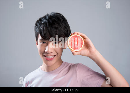 Jeune homme de manger le pamplemousse Banque D'Images