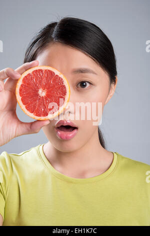 Jeune femme de manger du pamplemousse Banque D'Images