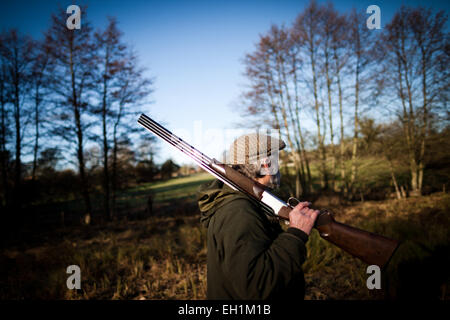 Photo d'un homme tenant un fusil sur son épaule sur un jeu tourner en Angleterre, Royaume-Uni Banque D'Images