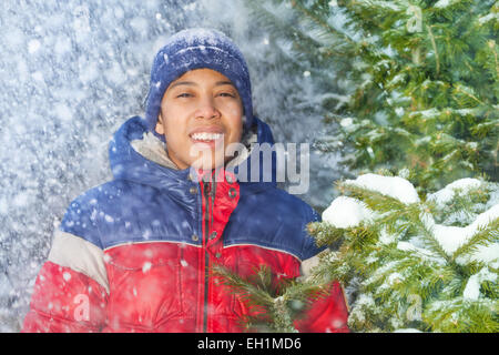 Portrait of smiling boy à la chute des flocons de neige Banque D'Images