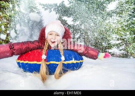 Fille excité sur snow tube en hiver pendant la journée Banque D'Images