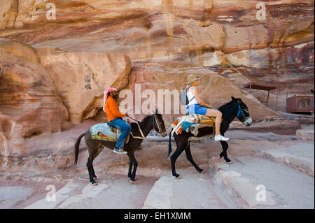 PETRA, JORDANIE - OCT 12, 2014 : deux ânes avec son propriétaire et le tourisme sont grimper le long escalier pour le Monastère Deir' Banque D'Images