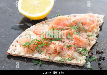 Saumon mariné, l'aneth et le poivre noir sur des biscottes. Banque D'Images