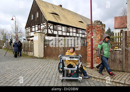 Un technicien du son est assis à côté de son matériel sur la place du village pendant le tournage d'une scène d'une comédie romantique en chinois Hoefgen, Allemagne, 2 mars 2015. La production chinoise raconte l'histoire d'un acteur non de Beijing qui, par coïncidence, achète une maison en Allemagne. Photo : Jan Woitas/dpa Banque D'Images