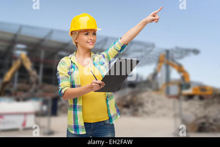 Smiling woman in casque avec presse-papiers Banque D'Images