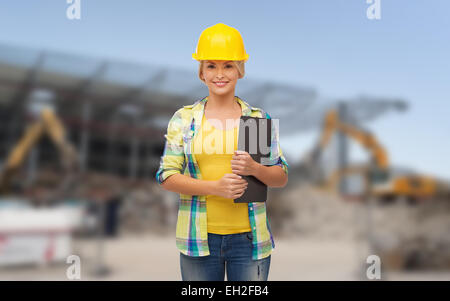 Smiling woman in casque avec presse-papiers Banque D'Images