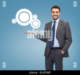 Smiling businessman holding l'icône de paramètres Banque D'Images