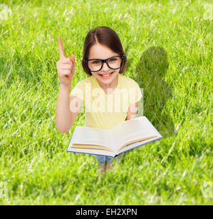 Smiling little girl à lunettes avec réserve Banque D'Images