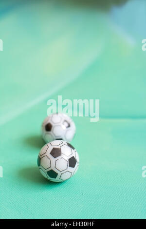 Ballons de soccer de jouet sur fond de toile verte. Banque D'Images