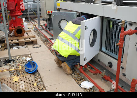 Les entrepreneurs en construction travaillant sur le chauffage et les installations électriques sur un nouveau projet de construction. Mars 2013 Banque D'Images