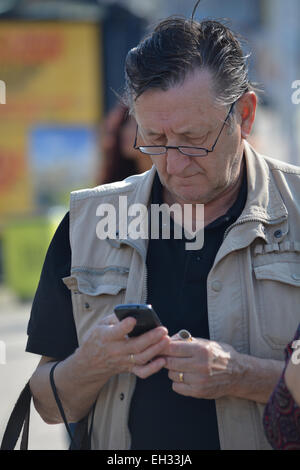 Senior man using cell phone Banque D'Images