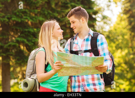 Smiling couple with map et sacs à dos en forêt Banque D'Images