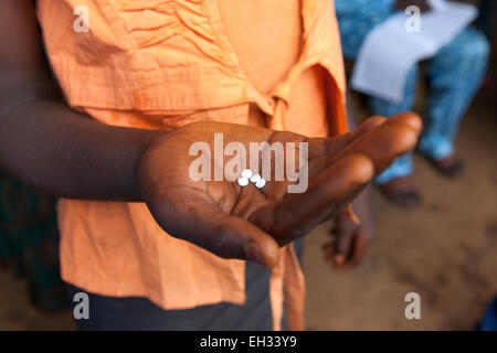 Bamenda, Cameroun, juillet 2013 : Une jeune femme sur le point de prendre son traitement Mectizan pour la protéger de l'onchocercose. Banque D'Images