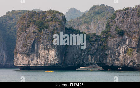 Canoës de tourisme entre les montagnes de calcaire karstique dans le parc national de Cat Ba, La Baie d'Halong,Ha Long, Ha Long, Halong Bay, Vietnam Banque D'Images