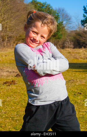 Une jeune fille souriante tout seul dans la forêt Banque D'Images