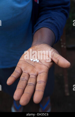 Bamenda, Cameroun, juillet 2013 : Une jeune femme sur le point de prendre son traitement Mectizan pour la protéger de l'onchocercose. Banque D'Images