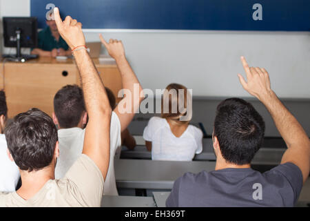 Les élèves répondent à une question et de mettre les mains en l'air Banque D'Images