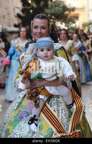 Une jeune mère en costumes traditionnels fallas tenant son petit garçon bien habillé à l'avant de l'appareil photo Banque D'Images