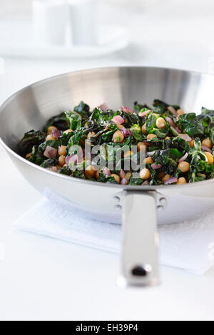 Les épinards et les légumes verts avec les pois chiches et les oignons rouges dans une poêle à frire, Studio Shot Banque D'Images