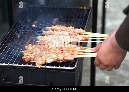 Satay de cuisson sur barbecue Banque D'Images