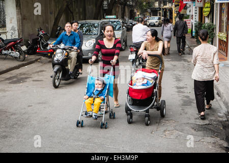 Deux femmes, mères avec poussettes, poussant les poussettes de leurs bébés, enfants à proximité de la cathédrale dans le vieux quartier de Han Noi, Hanoi, Vietnam, Banque D'Images