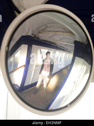 Homme marchant passé convex mirror sécurité étapes ci-dessus sur un passage pour piétons à la gare selby Royaume-Uni Banque D'Images