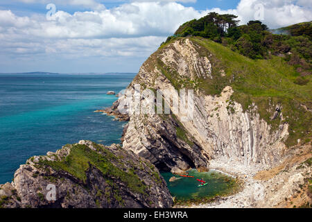 Les kayakistes de mer colorés explorer la fonction appelée trou de l'escalier sur la côte jurassique, Dorset, England, UK Banque D'Images