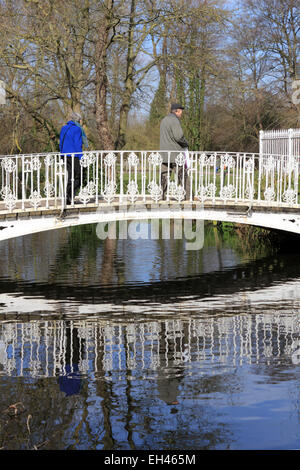 Morden Hall Park, South London, UK. 6 mars 2015. Lors d'une journée ensoleillée dans une grande partie de la France, la température a augmenté à 13 degrés dans le sud de Londres. Personnes bénéficiant d'une belle journée de printemps, avec un ciel bleu magnifique à Morden Hall Park, où la rivière Wandle passe sous le pont blanc. Credit : Julia Gavin UK/Alamy Live News Banque D'Images