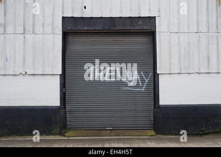 Entrepôt industriel avec spray graffiti peint sur la porte, le chemin à rouleaux Banque D'Images