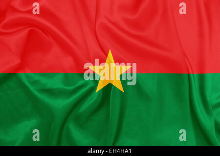 Burkina Faso - agitant le drapeau national sur la texture de la soie Banque D'Images