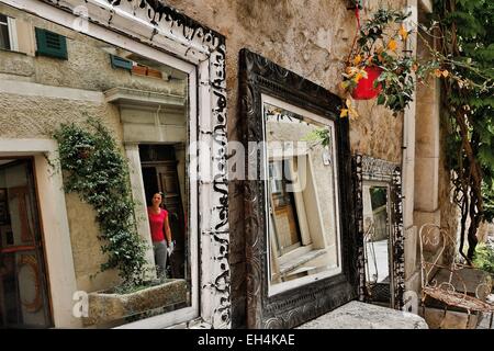 France, Alpes Maritimes, Grasse, reflet dans un miroir en face d'un antique établissant ses objets dans la rue Banque D'Images