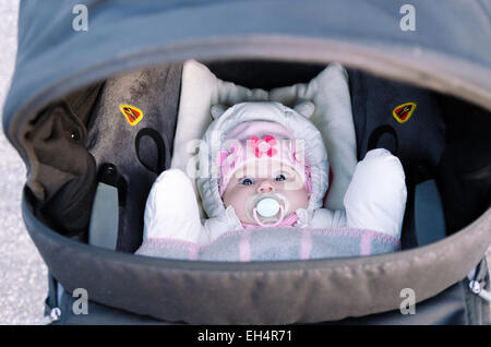 Un petit bébé couché dans un landau à droite dans l'appareil photo Banque D'Images