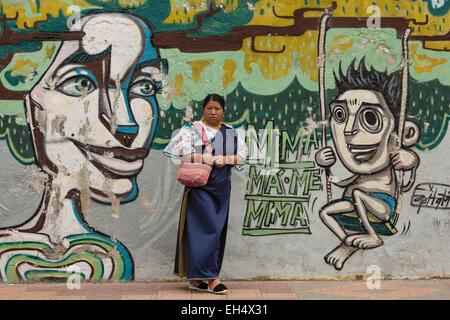 L'Équateur, Cotacaxi Intyrami, d'Imbabura, jour, portrait d'une femme vêtue de façon traditionnelle équatorienne en face d'un mur de graffiti Banque D'Images