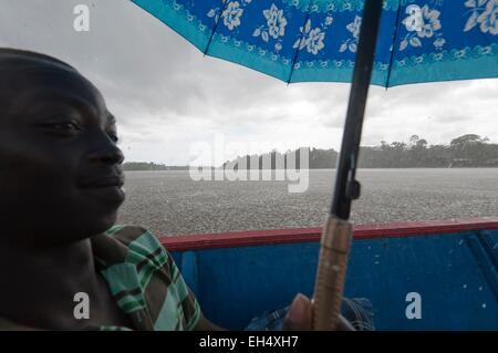 France, Guyane, Parc amazonien de Guyane (Parc amazonien de la Guyane), Grand Santi, un homme dans une pirogue tenant un parapluie, tempête tropicale sur la rivière Lawa devenir en aval du fleuve Maroni Banque D'Images
