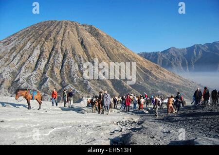 L'Indonésie, Java, Jawa Timur, le Parc National de Bromo-Tengger-Semeru, touristes, gens du pays et les chevaux au pied du Mont Bromo, le mont Batok dans l'arrière-plan Banque D'Images