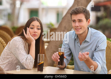 L'homme et la femme à une terrasse de restaurant mais elle est plate alors qu'il parle Banque D'Images