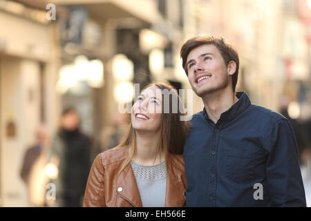 Couple en train de marcher et à au-dessus de la rue d'une ville Banque D'Images