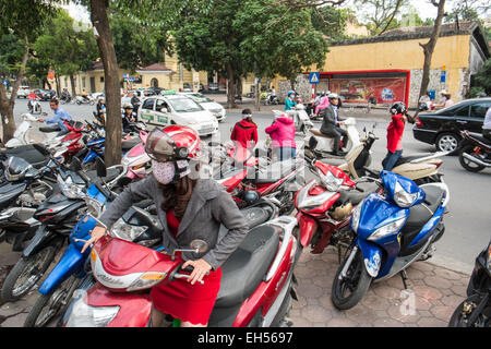 Jeune femme très tendance avec masque de visage est sur ses scooters en stationnement. La pollution,Scooters,du bruit, de la circulation, Ha Noi, Hanoi, Vietnam, Banque D'Images