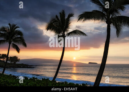 Coucher de soleil au large des silhouettes et des îles Hawaii Molokini de Makena Beach sur l'île de Maui. Banque D'Images