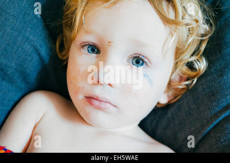 Jeune blonde en oreiller denim looking up Banque D'Images