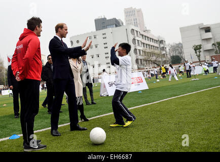 Beijing, Chine. 3e Mar, 2015. Le prince William interagit avec un étudiant au cours d'une visite à un camp d'entraînement de Premier League à l'école secondaire Nanyang à Shanghai, la Chine orientale, le 3 mars 2015. © Liangkuai Jin/Xinhua/Alamy Live News Banque D'Images