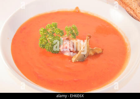 Un bol de soupe aux tomates blanc blanc, rempli de champignons et bacon Banque D'Images