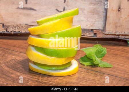 Une tour de citron et de lime slice, presque neuf. Sur fond de bois Banque D'Images