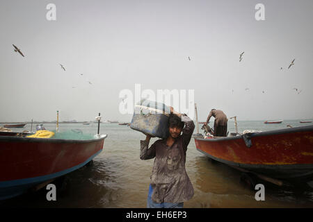 Chabahar, Iran. 7 mars, 2015. Un pêcheur iranien porte une boîte de poisson dans le port de la ville de Chabahar, en Iran, le 7 mars 2015. © Ahmad Halabisaz/Xinhua/Alamy Live News Banque D'Images