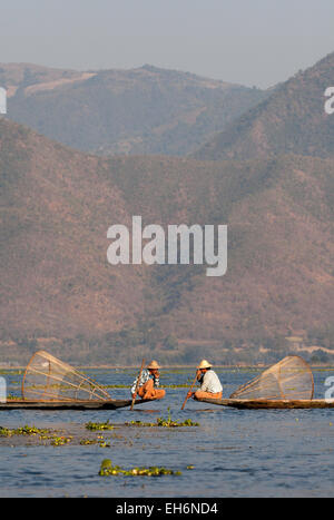 Jambe deux pêcheurs pêche, aviron au Lac Inle, Myanmar ( Birmanie ), l'Asie Banque D'Images