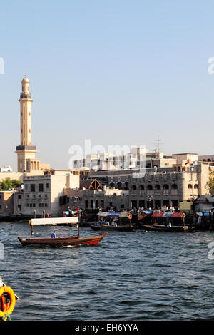 Vue sur la Crique de Dubaï de Deira à Bur Dubaï. Abras, typique ferry boats à Dubaï, traversent la rivière ; le minaret de la G Banque D'Images