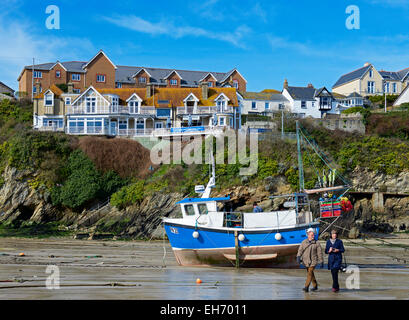 Bateau de pêche passé couple walking on beach in Port, Newquay, Cornwall, England UK Banque D'Images