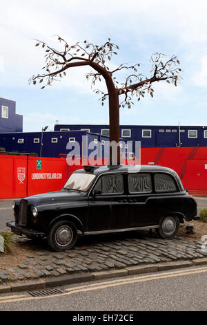 Une sculpture d'un taxi avec un métal de plus en plus d'arbres à travers elle par Andrew Baldwin sur un rond-point, Orchard Place, London, UK. Banque D'Images