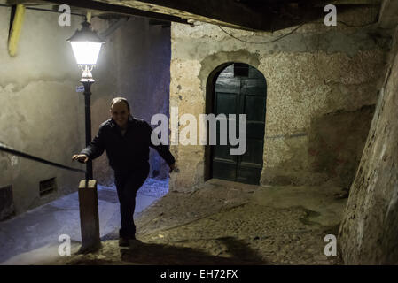 Un homme grimpe sur les rues étroites avec les étapes de Santa Maria del Monte à Varese, Italie illminated au crépuscule Banque D'Images