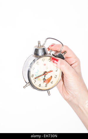 Main tenant une horloge vintage sur fond blanc Banque D'Images